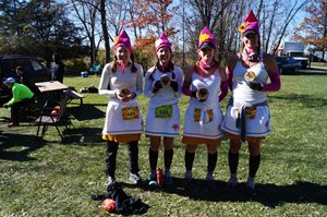 Four runners dresses as gnomes holding finishers plaques
