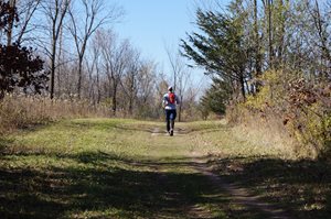 Runner with back to camera running on trail